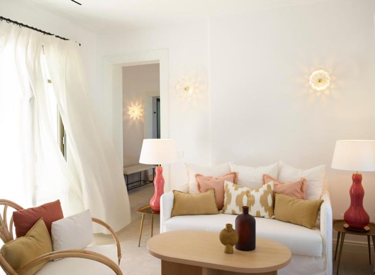 a living room with a white couch and a table at Bonzoe Suites Villas in Mikonos 768x564