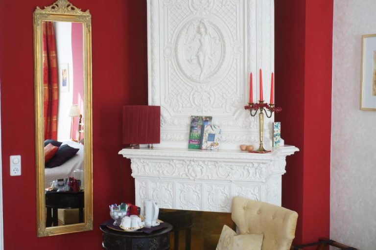 a living room with a white fireplace and a mirror at Boutique Hotel Mittendrin Berlin in Berlin 768x511