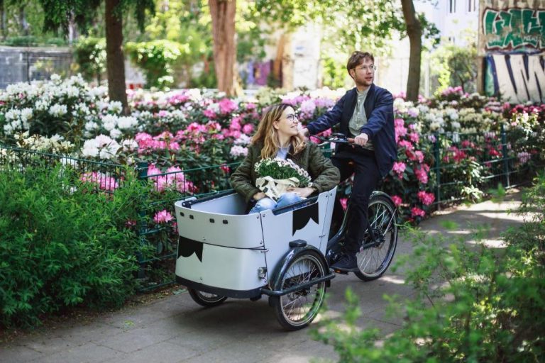 a man and a woman riding a bike with a basket at The Circus Apartments in Berlin 768x512