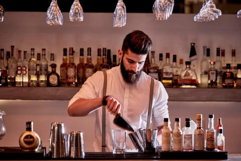 a man standing at a bar preparing a drink at Boheme Mykonos Town Small Luxury Hotels of the World in Mikonos 768x512