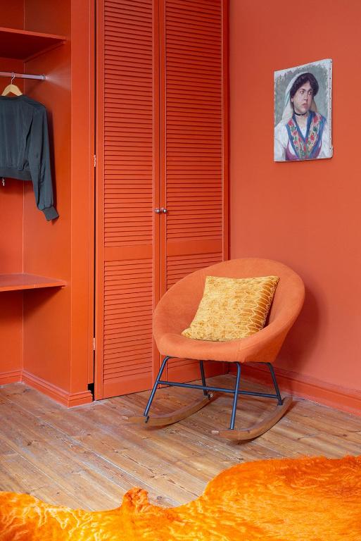 a orange chair with a yellow pillow in a room at Hotel Art Nouveau am Kurfurstendamm in Berlin