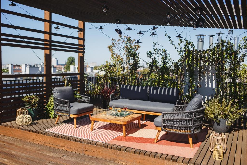 a patio with a couch and chairs and a table at The Circus Apartments in Berlin