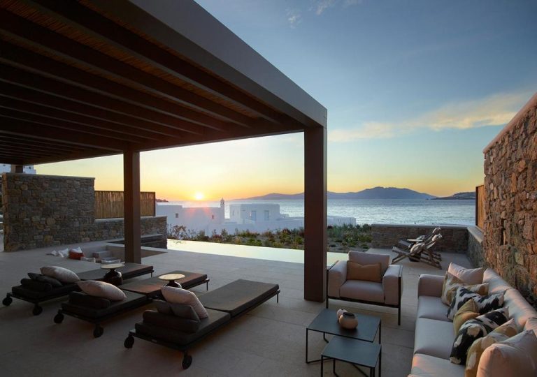 a patio with a view of the ocean at sunset at Bonzoe Suites Villas in Mikonos 768x540