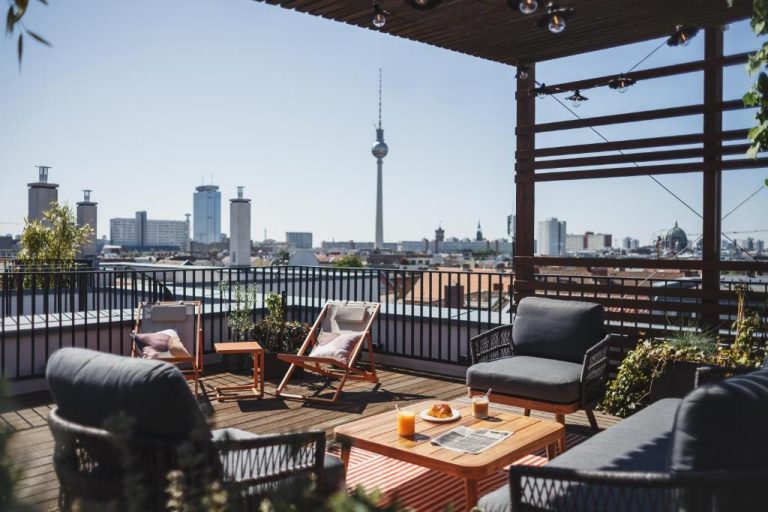 a patio with chairs and a table on a roof at The Circus Apartments in Berlin 768x512