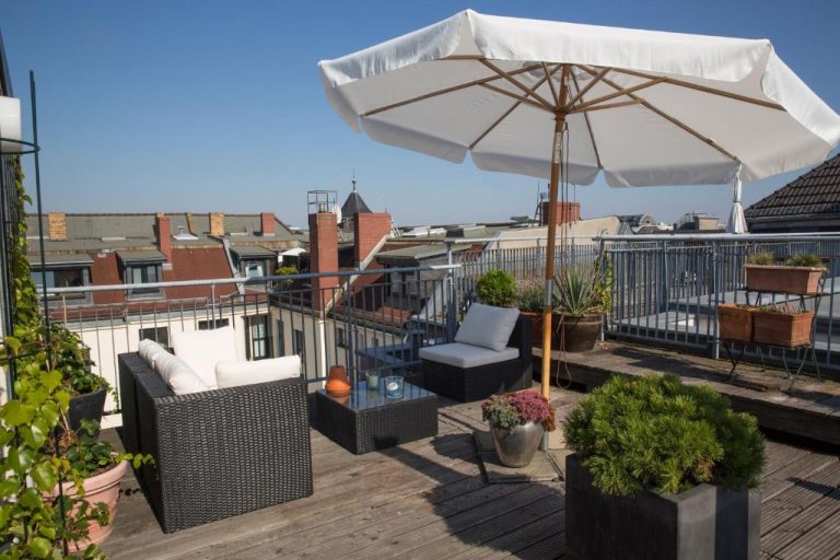 a patio with chairs and an umbrella on a roof at Hotel Art Nouveau am Kurfurstendamm in Berlin 768x512