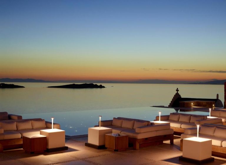 a pool with couches and a view of the water at BillCoo Mykonos The Leading Hotels of the World in Mikonos 768x561