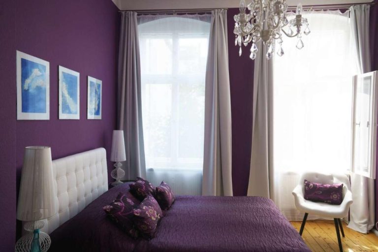 a purple bedroom with a bed and a chandelier at Boutique Hotel Mittendrin Berlin in Berlin 1 768x512