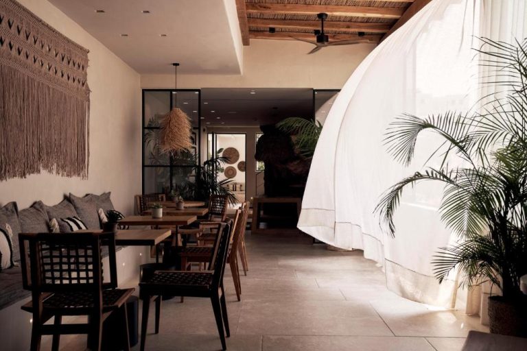 a restaurant with tables and chairs in a room at Amyth of Mykonos Agios Stefanos in Agios Stefanos 768x512