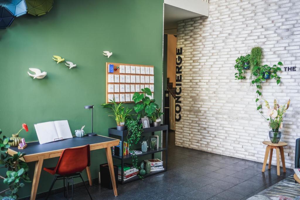 a room with a desk and plants on the wall at The Circus Apartments in Berlin