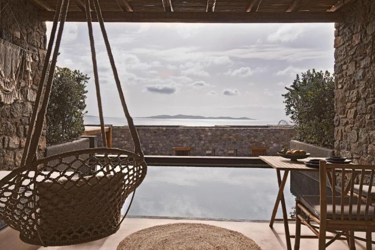 a room with a large window with a table and chairs at Amyth of Mykonos Agios Stefanos in Agios Stefanos 768x512