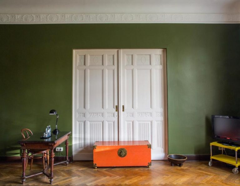 a room with green walls and a door and a desk at Hotel Art Nouveau am Kurfurstendamm in Berlin 768x596