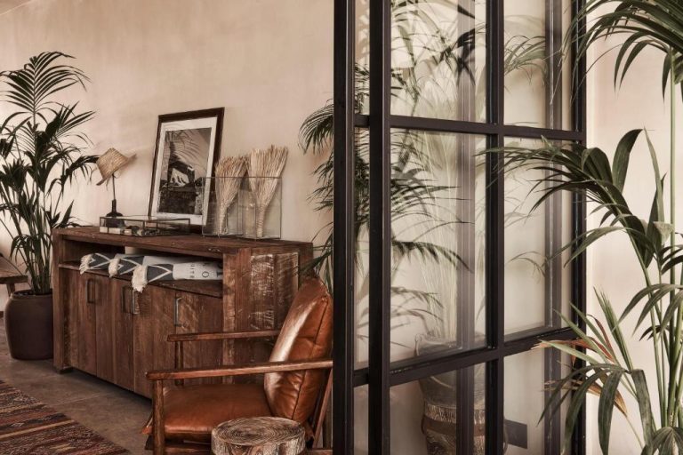 a room with plants and a chair and a mirror at Amyth of Mykonos Agios Stefanos in Agios Stefanos 768x512