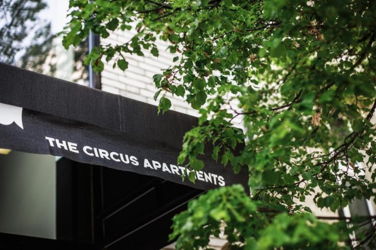 a sign that reads the chrysalisarinearinearts in front of a tree at The Circus Apartments in Berlin 768x512