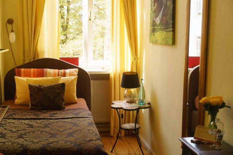 a small bedroom with a bed and a window at Boutique Hotel Mittendrin Berlin in Berlin 768x512