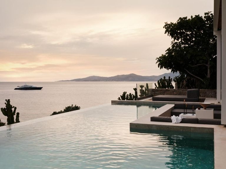 a swimming pool with a cruise ship in the water at BillCoo Mykonos The Leading Hotels of the World in Mikonos 768x576