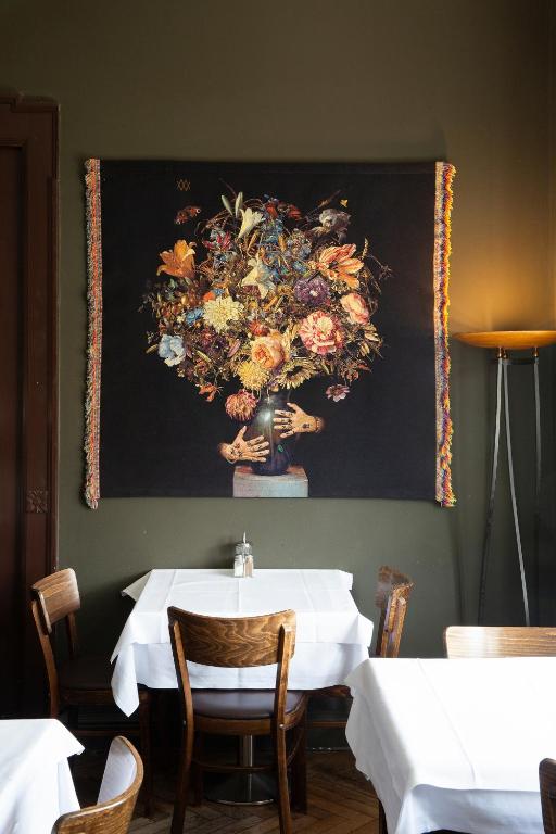 a table in a restaurant with a painting on the wall at Hotel Art Nouveau am Kurfurstendamm in Berlin