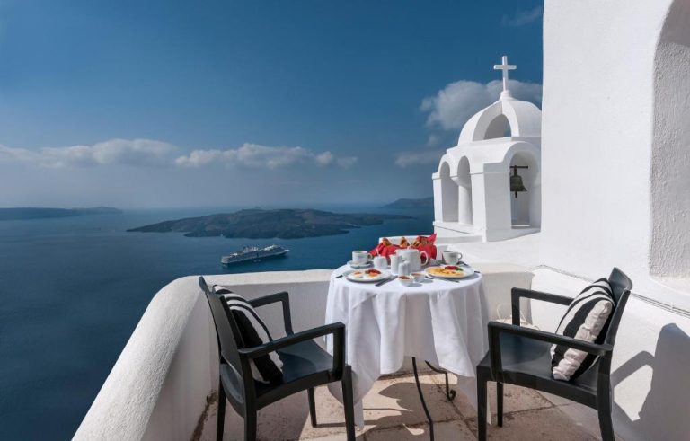 a table on a balcony with a view of the ocean at Aigialos Luxury Traditional Settlement in Fira 768x491