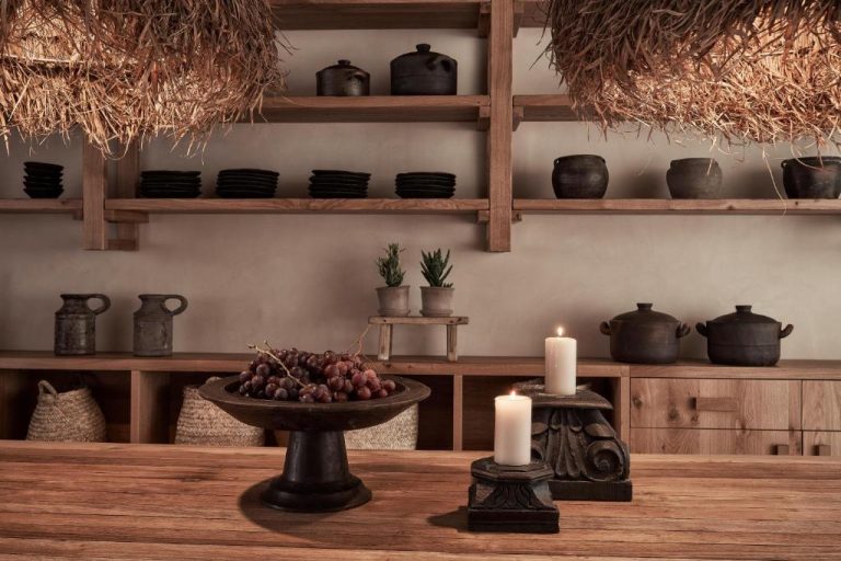 a table with two candles and a bowl of fruit at Amyth of Mykonos Agios Stefanos in Agios Stefanos 768x512