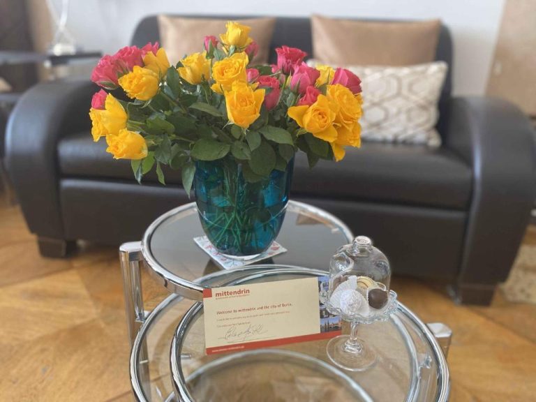 a vase of flowers sitting on a glass table at Boutique Hotel Mittendrin Berlin in Berlin 768x576