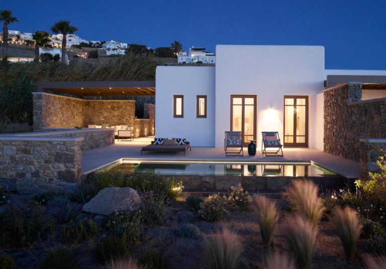 a villa with a swimming pool at night at Bonzoe Suites Villas in Mikonos 768x535