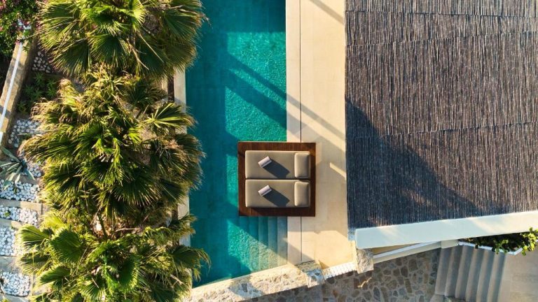 a wall with a box of mail next to a palm tree at BillCoo Mykonos The Leading Hotels of the World in Mikonos 768x432