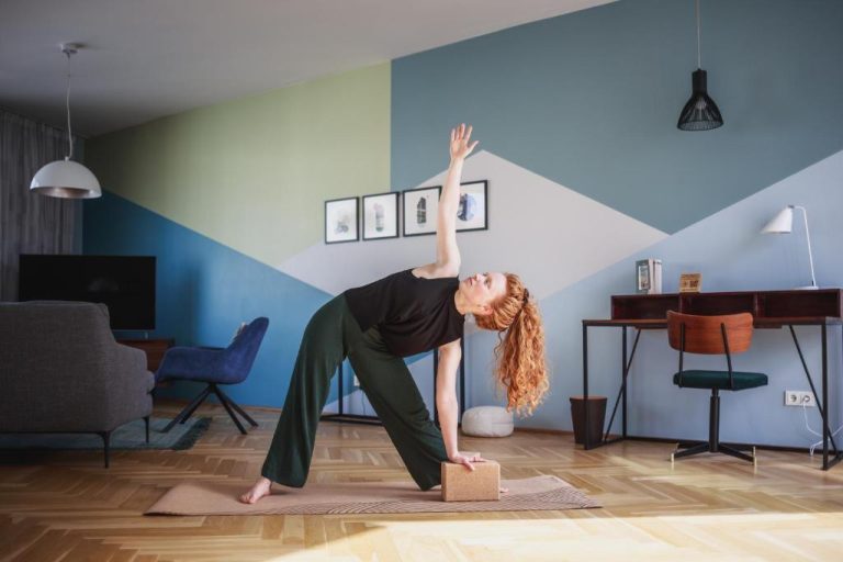 a woman in a room doing a yoga pose with a box at The Circus Apartments in Berlin 768x512