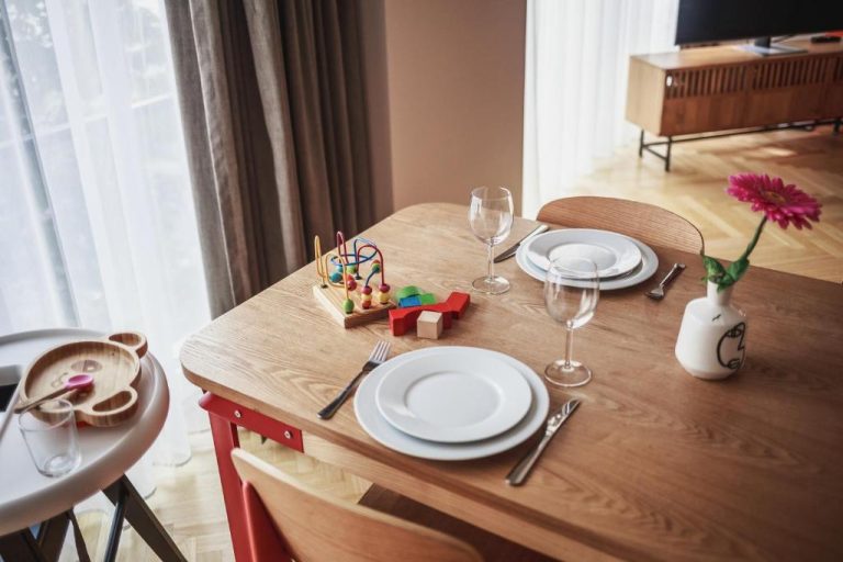 a wooden table with plates and wine glasses on it at The Circus Apartments in Berlin 768x512