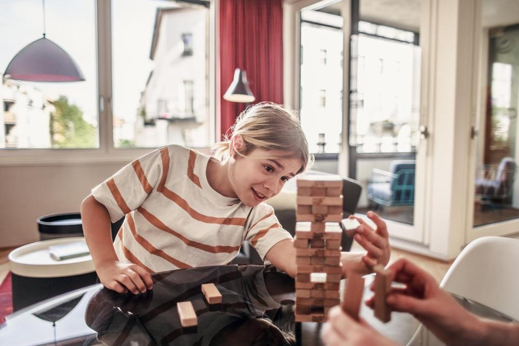 a young woman playing with a wooden chess set at The Circus Apartments in Berlin