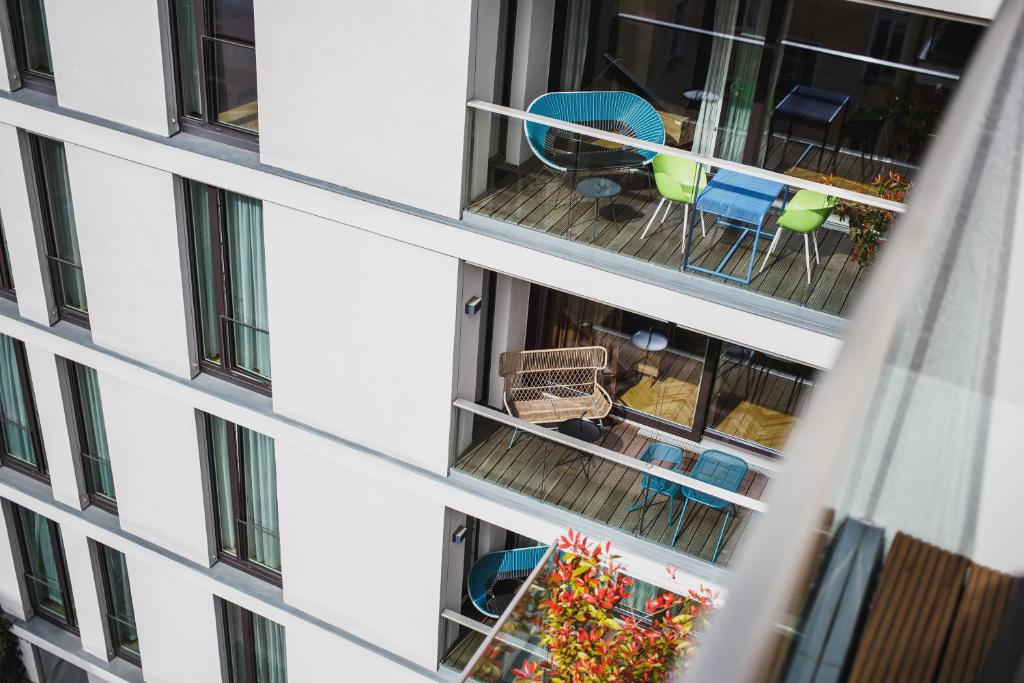 an apartment building with a balcony with chairs and tables at The Circus Apartments in Berlin