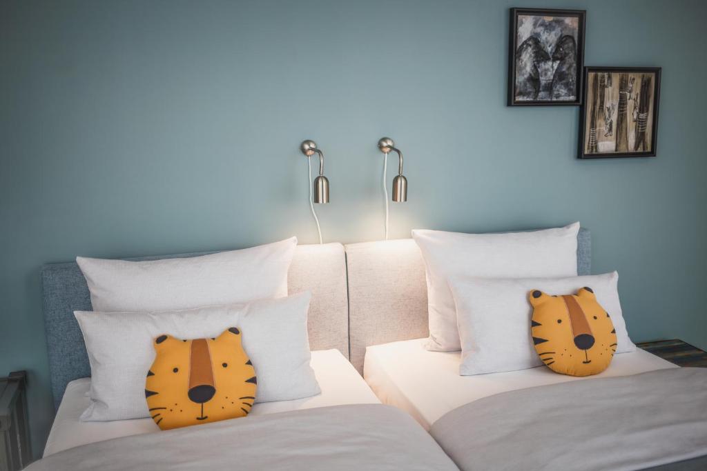 two beds with cats pillows on them in a room at The Circus Apartments in Berlin