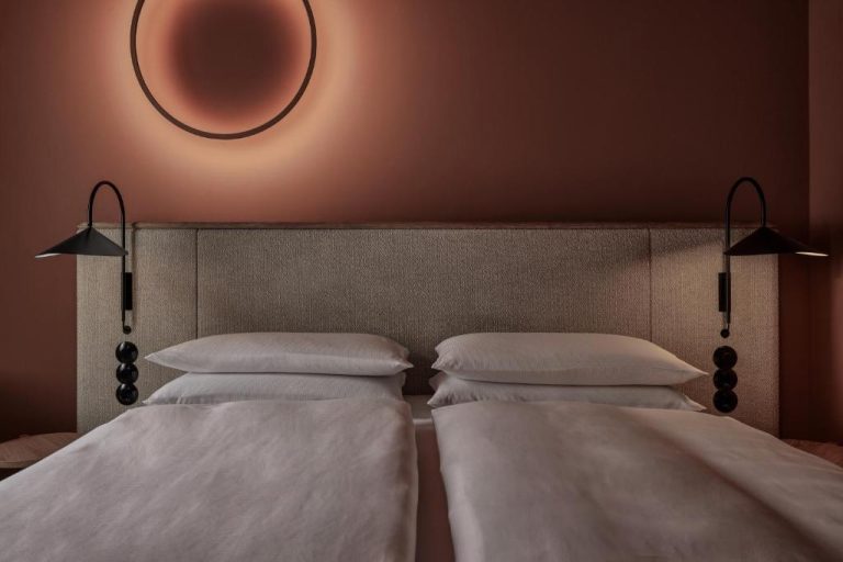 two beds with pillows and a mirror on the wall at ADELANTE Boutique Hotel in Berlin 768x512