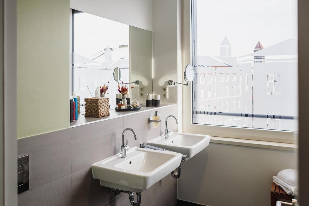 two sinks in a bathroom with a large window at The Circus Apartments in Berlin